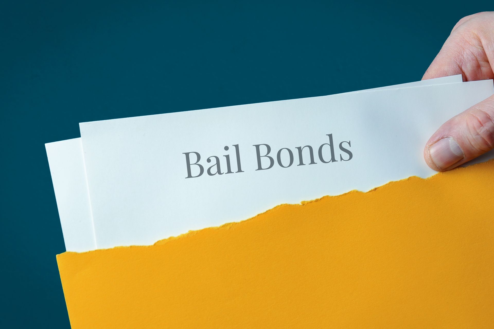 Bail bonds document in a yellow folder being held by a hand. Bail bonds document in a yellow folder being held by a hand.