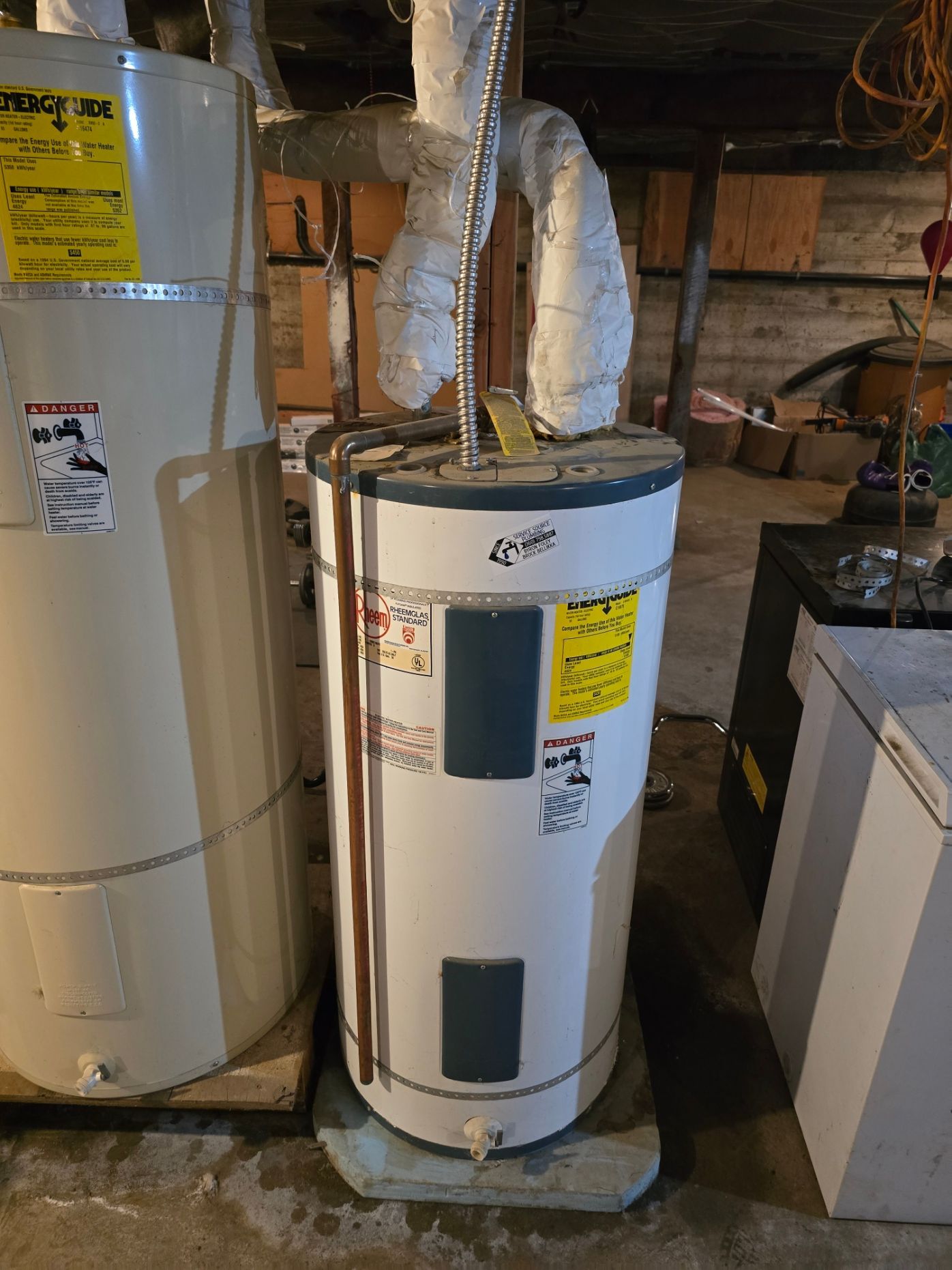 Basement utility area with a white water heater and ducted HVAC equipment beside a furnace.