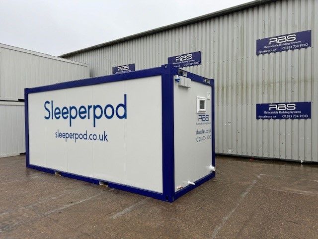 A sleeperpod is sitting in front of a building