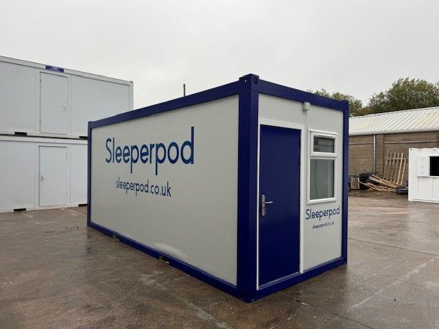 A sleeperpod container is sitting in a parking lot