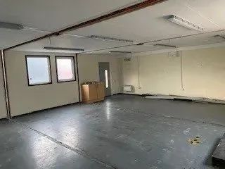 Empty portakabin interior with two boxes on the floor and a radiator on the wall