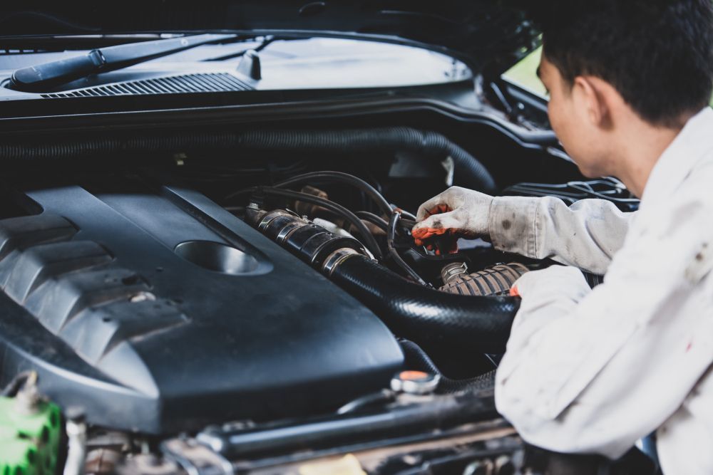 A man is working on the engine of a car.