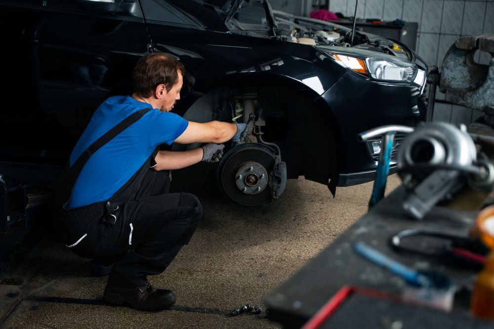 A man is working on a car in a garage.