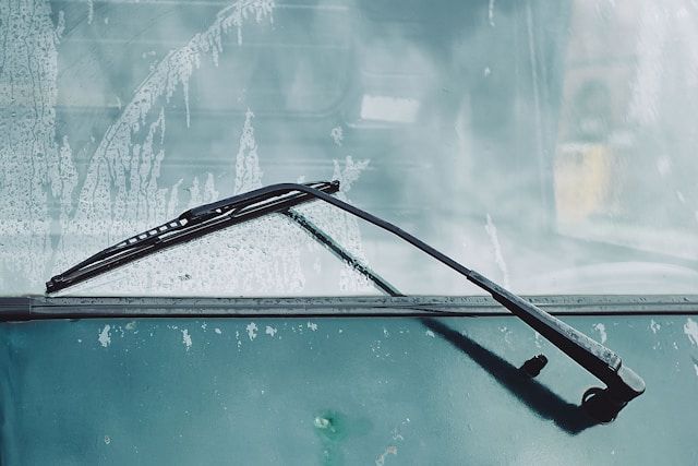 A close up of a windshield wiper on a car window.