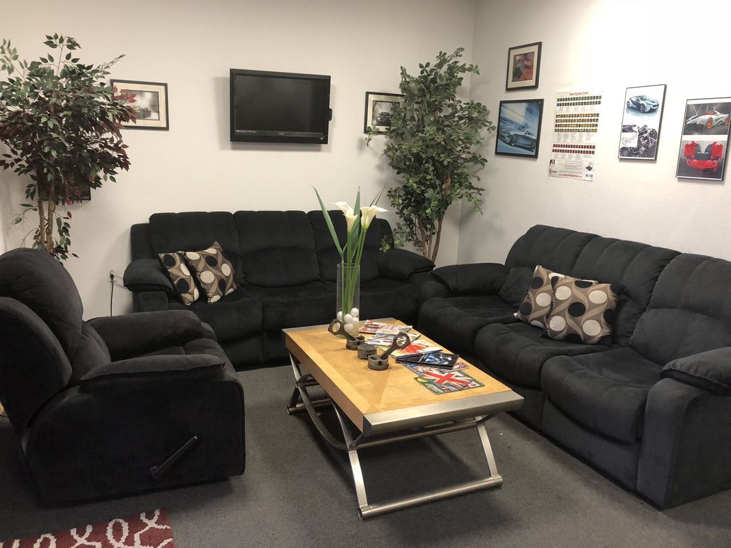 A living room with black couches and chairs and a coffee table