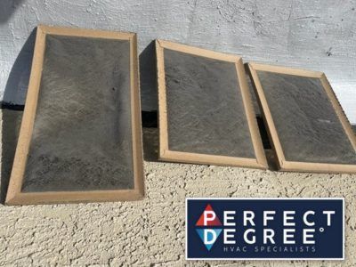 Three dirty air filters with cardboard frames sit outdoors; Perfect Degree logo in corner.