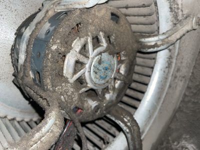 A dusty blower motor in an HVAC unit.