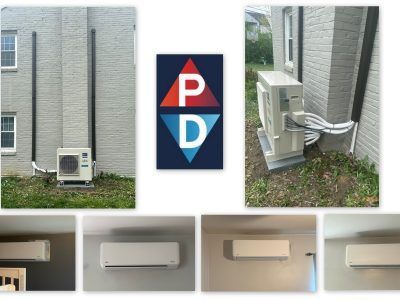 Mini-split AC system installed on brick building exterior and interior with company logo in the center.