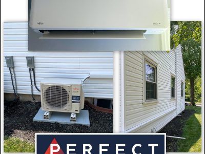 Fujitsu mini-split AC unit installed on a white house, with outdoor compressor, and indoor wall unit.