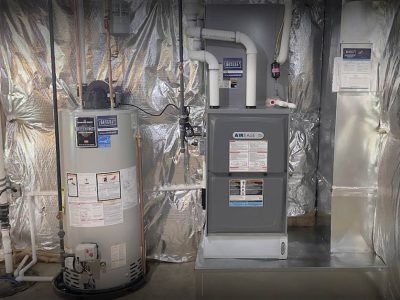 A residential furnace and water heater in a utility room with foil insulation.