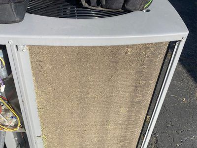 Dirty air conditioner filter covered in debris.