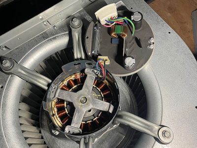 Fan motor assembly, open. Electrical components visible, metal fan blades surround the motor.