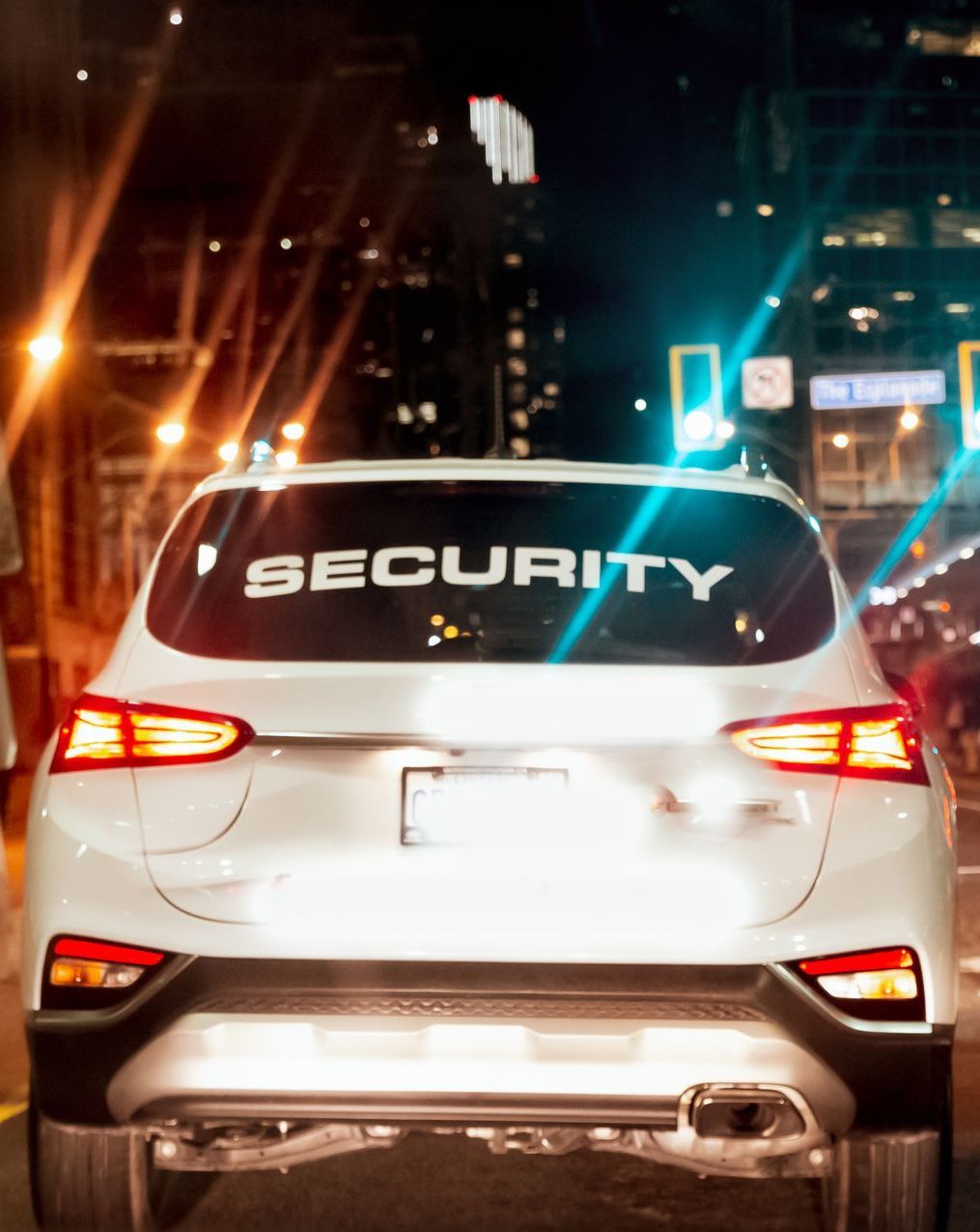 A white car with the word security on the back window