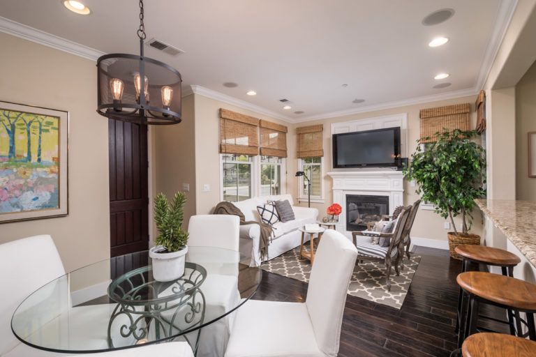 Living and dining area with a table, chairs, sofa, fireplace, and window coverings.
