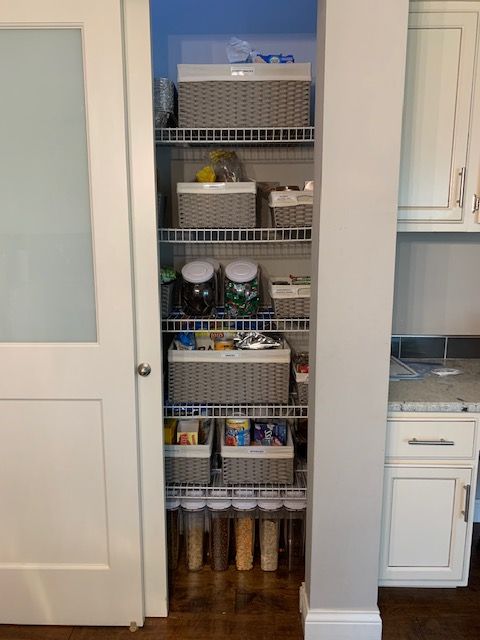 A pantry filled with lots of containers and baskets in a kitchen.