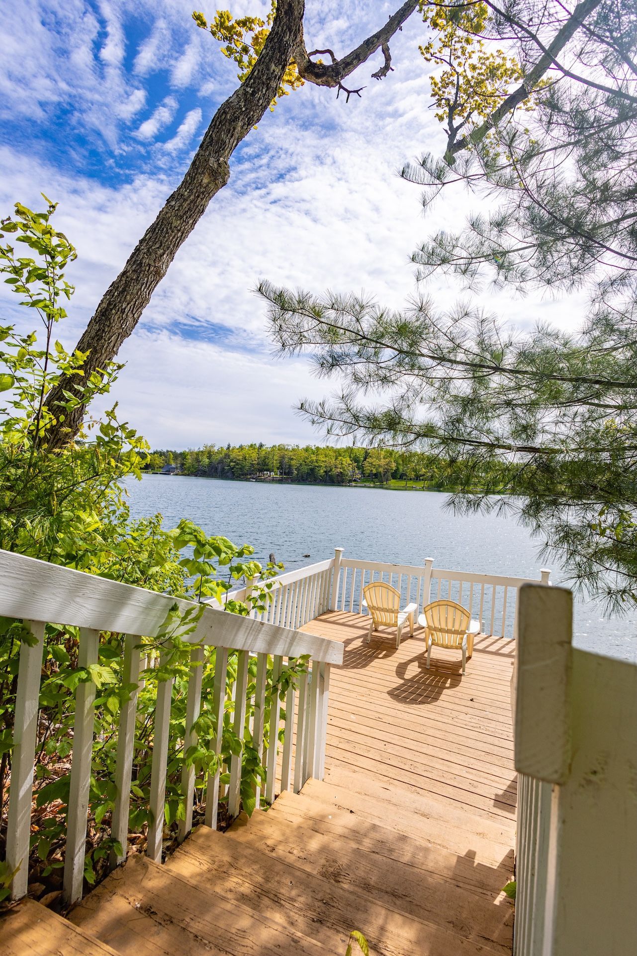 There are stairs leading up to a deck overlooking a lake.
