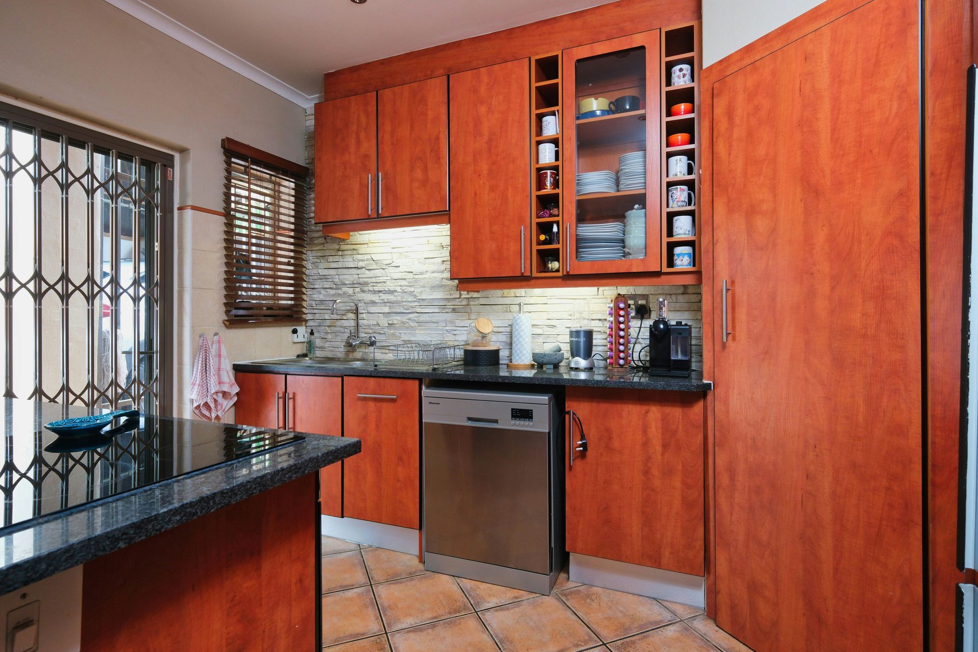 A kitchen with wooden cabinets and a stainless steel dishwasher.