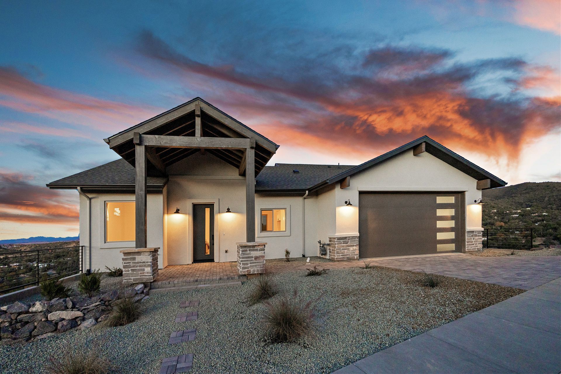 Front view of a custom cliffside home on Jordin Drive in Prescott, AZ, illuminated at night, showcasing modern architecture and expert craftsmanship.