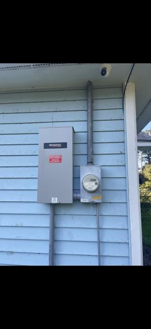 An electrician is working on an electrical outlet with a screwdriver.