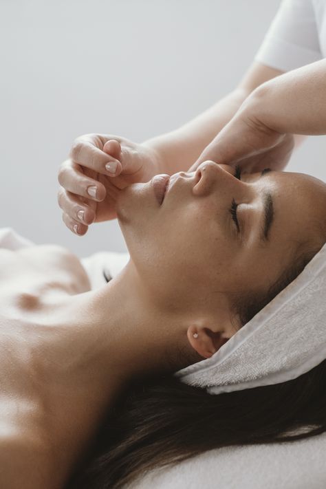 Een vrouw krijgt een gezichtsmassage in een spa.
