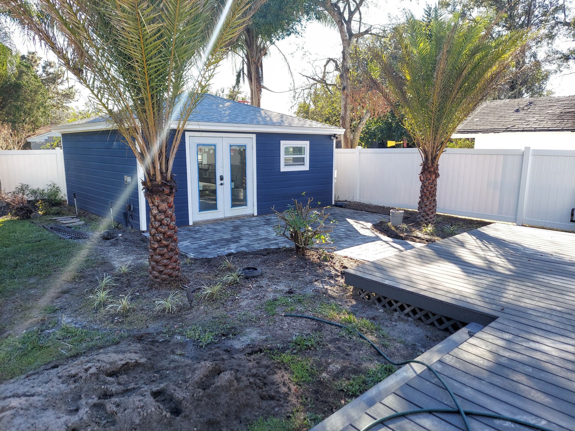 A blue house with two palm trees in front of it.