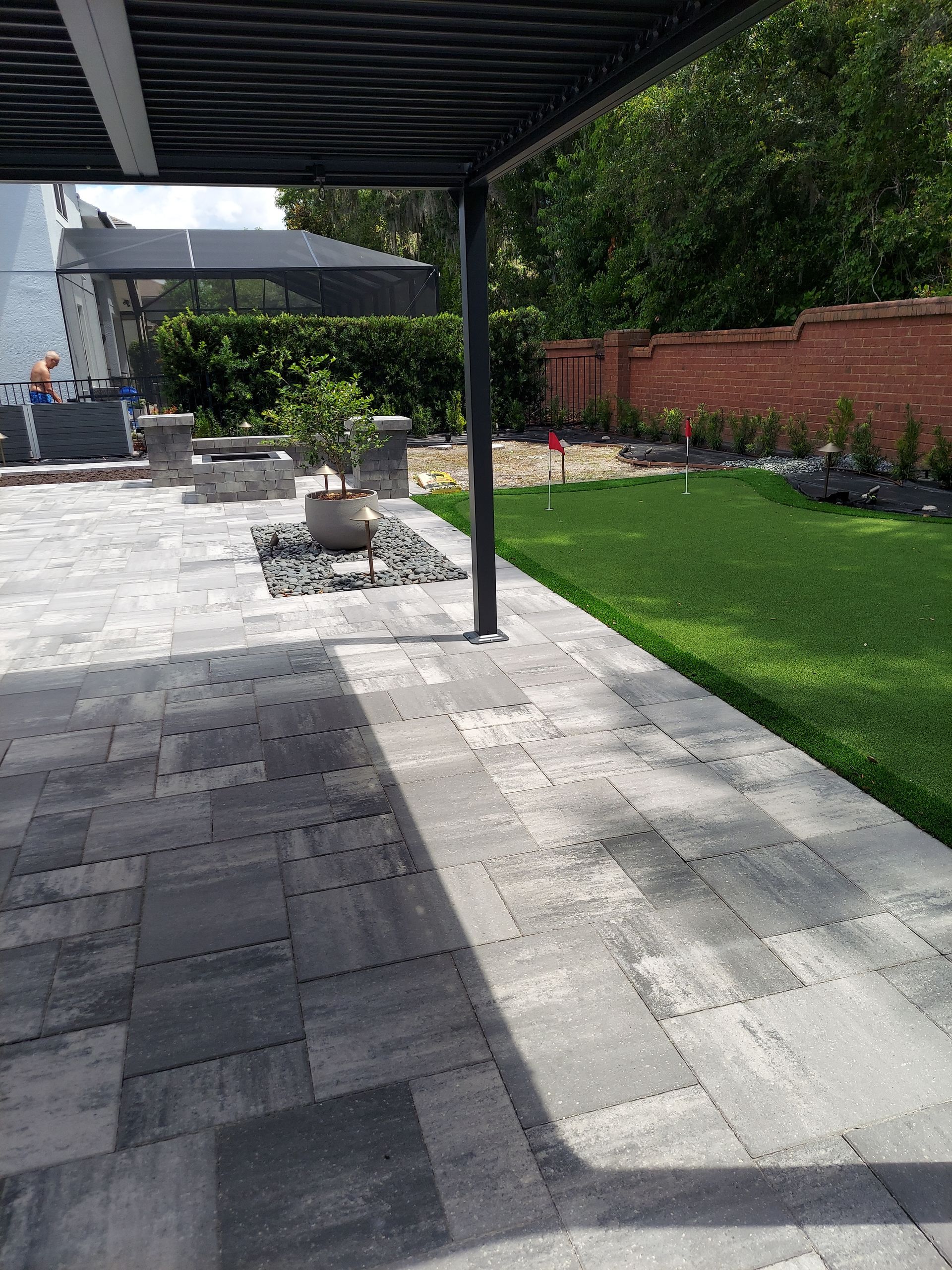 A patio with a pergola and a fire pit in the backyard.
