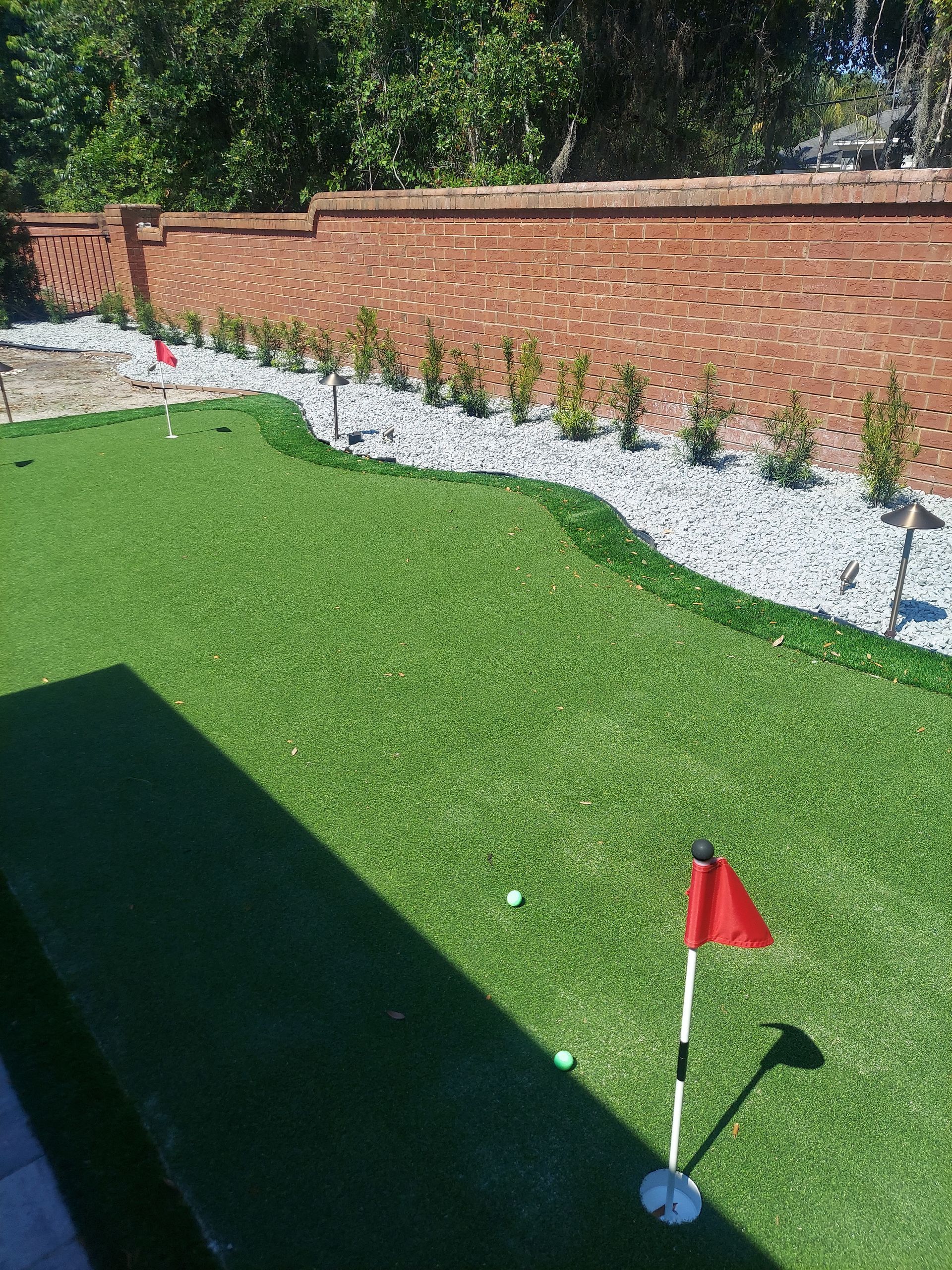 A golf course with a red flag on the green.