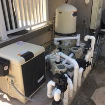 A swimming pool with a lot of pipes and pumps.