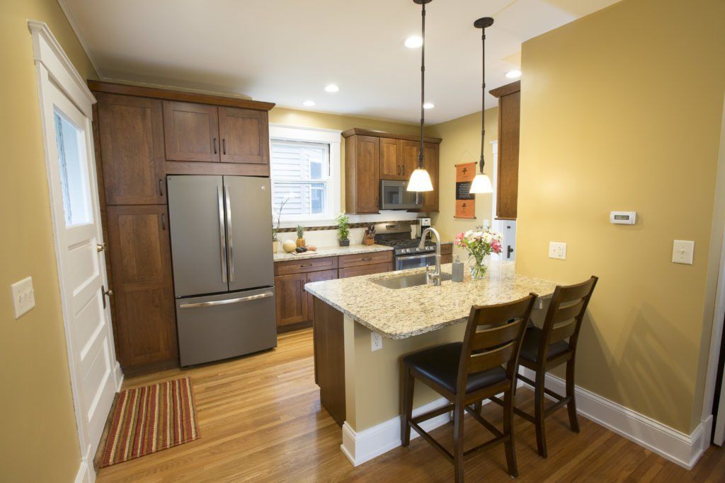 A kitchen with a stainless steel refrigerator and granite counter tops