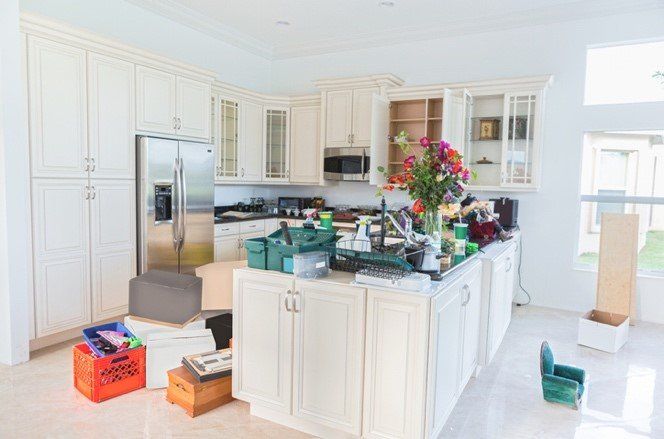 A kitchen with white cabinets and a stainless steel refrigerator.