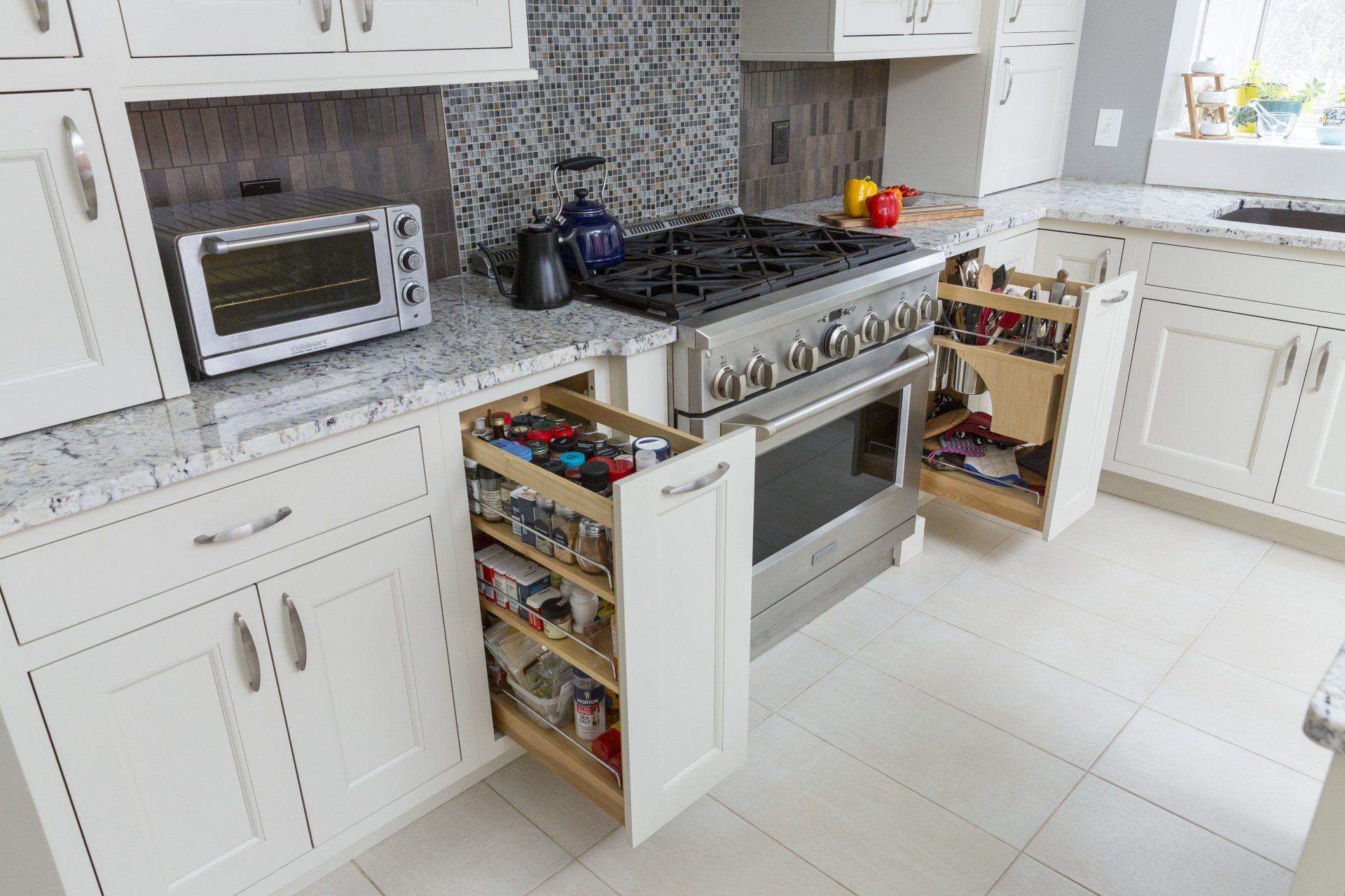 A kitchen with a stove , oven , microwave and drawers open.