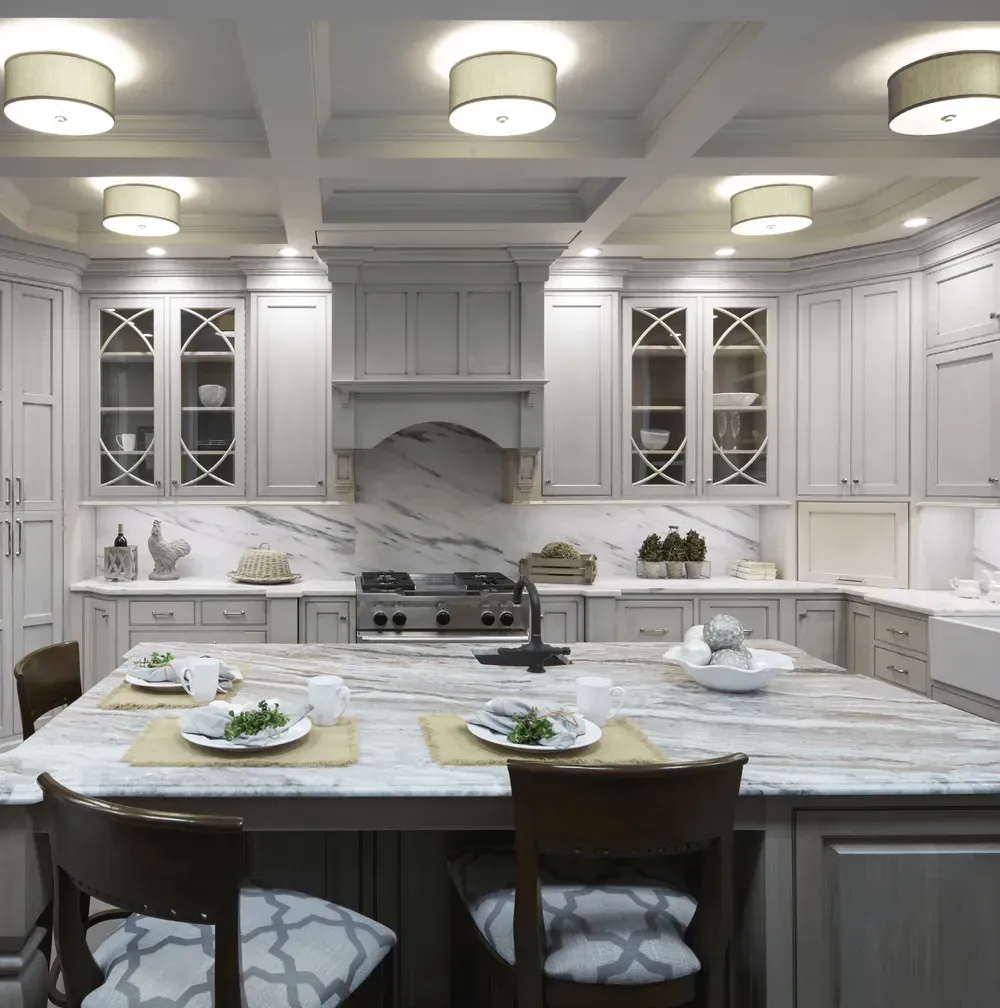 A kitchen with white cabinets and a marble countertop