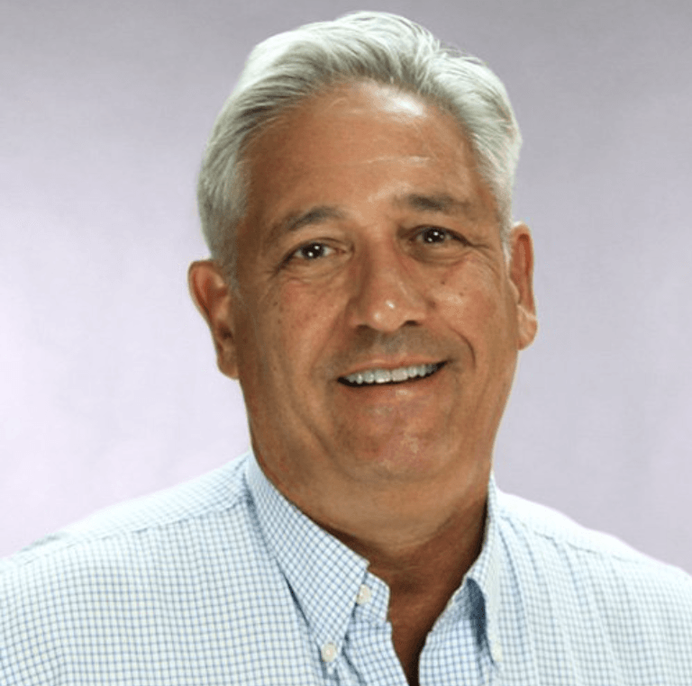 A man in a plaid shirt is smiling for the camera.