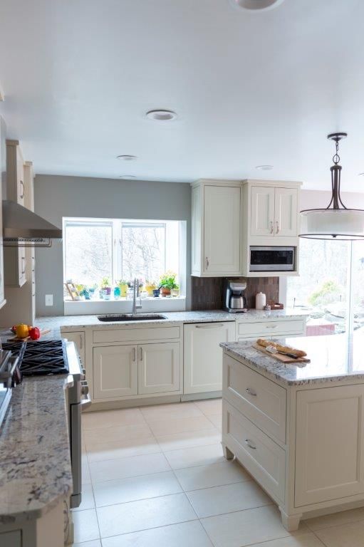 A kitchen with white cabinets and granite counter tops