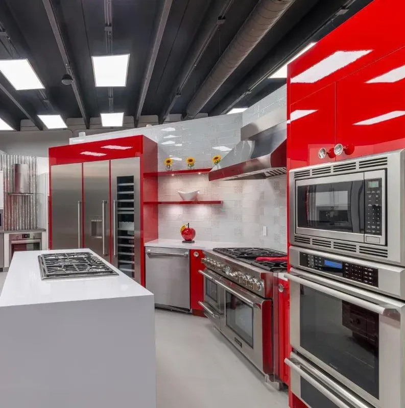 A kitchen with red cabinets and stainless steel appliances