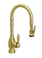 A close up of a brass kitchen faucet on a white background.