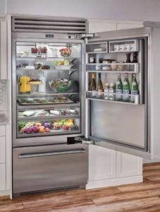 A stainless steel refrigerator with the door open in a kitchen.