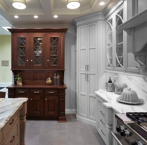 A kitchen with white cabinets and wooden cabinets