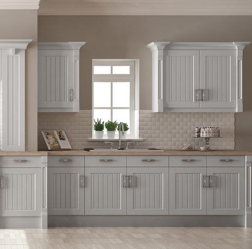 A kitchen with white cabinets and a sink and a window