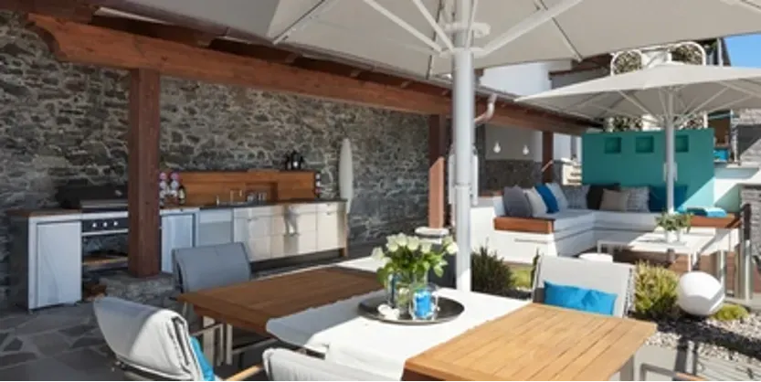 A patio with a table and chairs under umbrellas