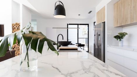 A kitchen with white cabinets and stainless steel appliances and a large island.