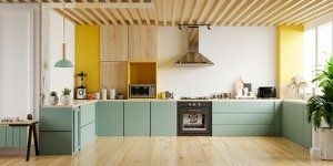 A kitchen with green cabinets and yellow walls and a wooden ceiling.