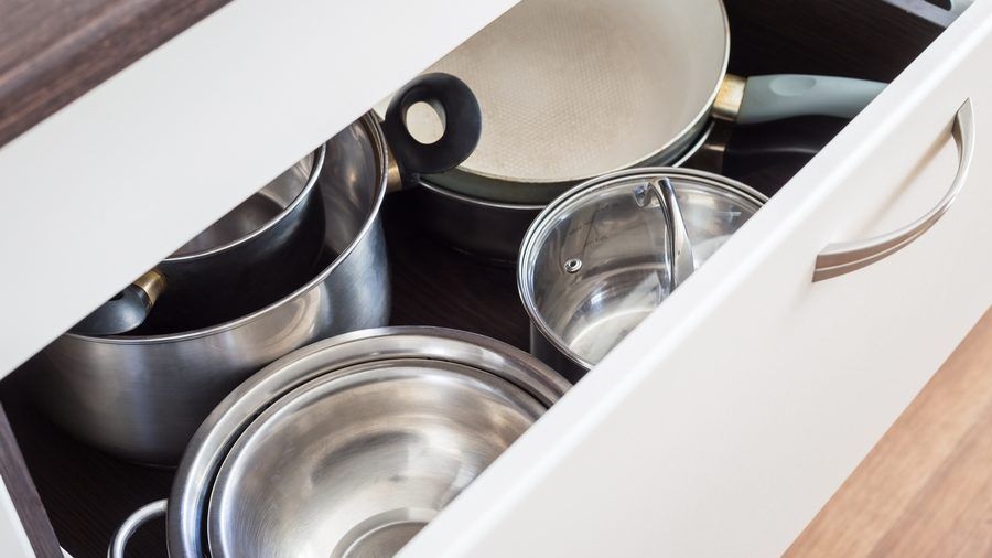 A kitchen drawer filled with pots and pans.