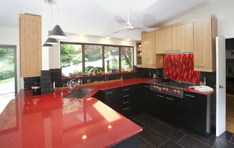 A kitchen with black cabinets and red counter tops