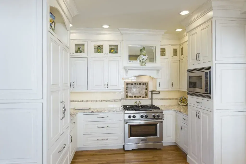 A kitchen with white cabinets and stainless steel appliances.