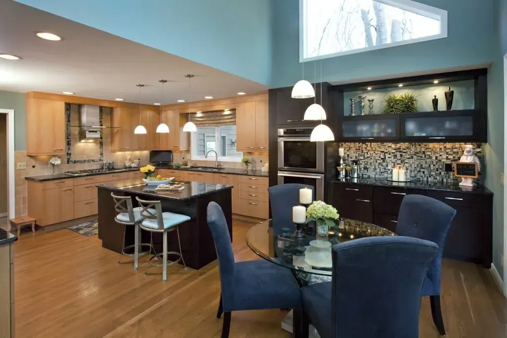 A kitchen with a dining table and chairs in it