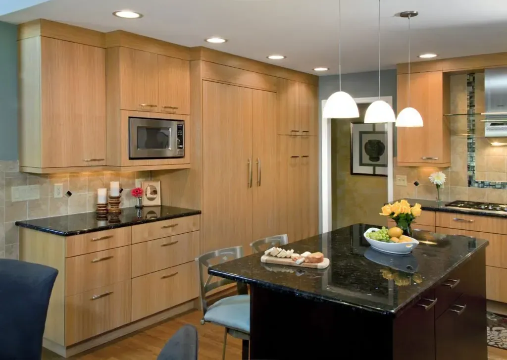 A kitchen with wooden cabinets and black granite counter tops