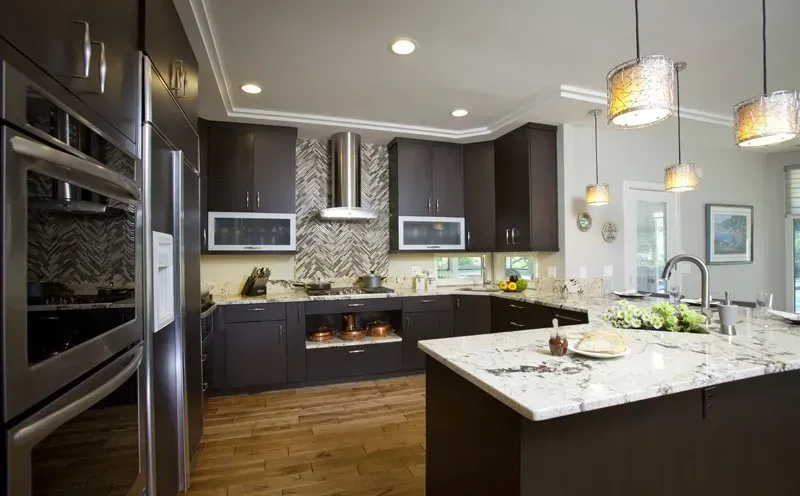 A kitchen with stainless steel appliances and marble counter tops.