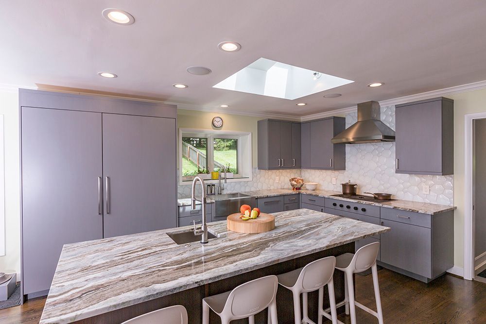 A kitchen with a large island and a skylight above the sink.