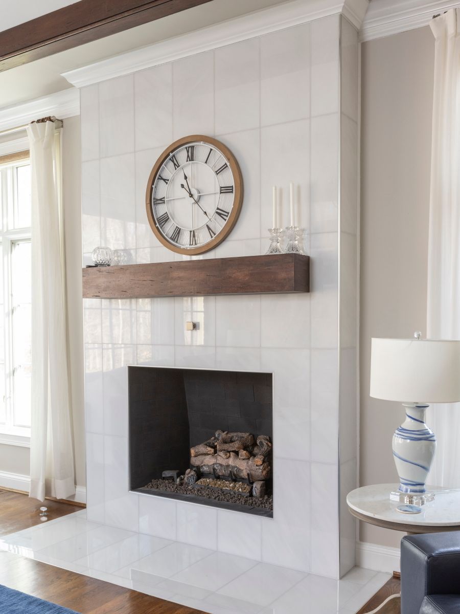 A living room with a fireplace and a clock above it